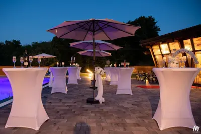 a row of tables and chairs with purple umbrellas at Villa Djuric in Slatina Varoš