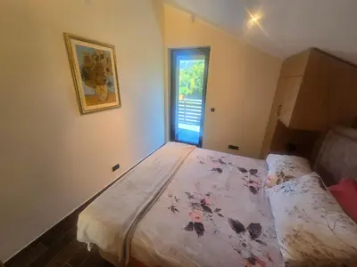 a small bedroom with a bed with a window at Villa Djuric in Slatina Varoš