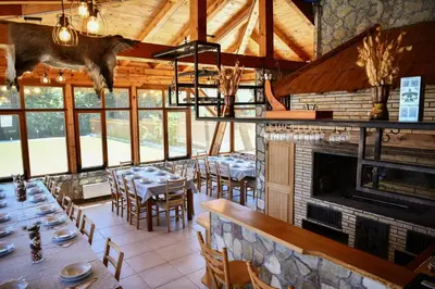 a restaurant with tables and chairs and a fireplace at Villa Djuric in Slatina Varoš