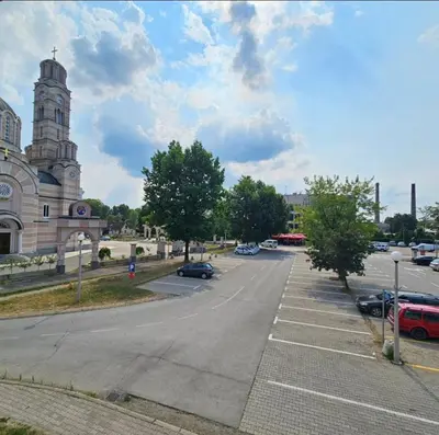 an empty parking lot in front of a church at Stan TeslićTrg in Teslić