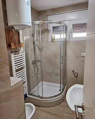 a bathroom with a shower and a toilet and a sink at Stan TeslićTrg in Teslić
