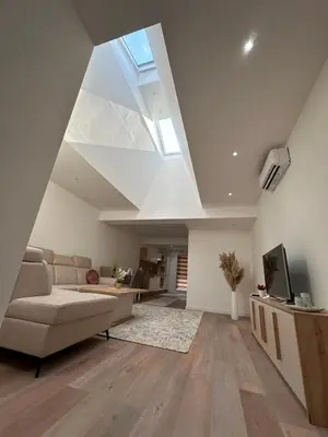 a living room with a couch and a skylight at Luxury Pyramid Apartment Visoko in Visoko