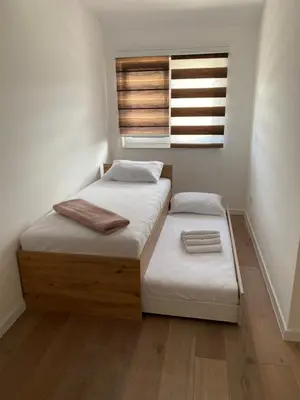 two beds in a small room with a window at Luxury Pyramid Apartment Visoko in Visoko