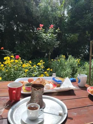 a table with a plate of food and cups of coffee at Apartman Turizam Plus in Travnik