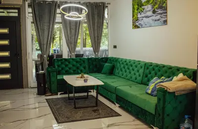 a green couch in a living room with a table at Natura na Uni in Bihać