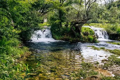 a waterfall in the middle of a river at Natura na Uni in Bihać