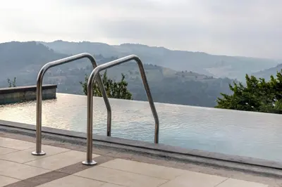 a swimming pool with two metal rails next to the water at Green Sea Resort - Zeleno More in Visoko