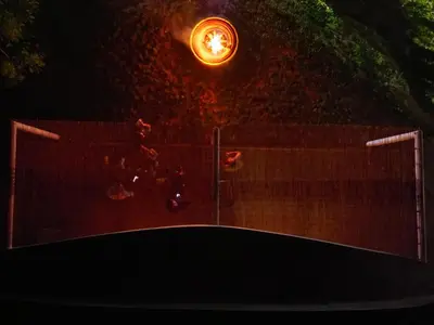 a group of people jumping on a fence at night at Green Sea Resort - Zeleno More in Visoko