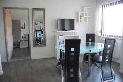 a dining room with a glass table and black chairs at Apartmani i Bungalovi TROJKA in Banja Luka