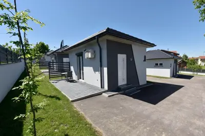 a house with a driveway in front of it at Apartmani i Bungalovi TROJKA in Banja Luka