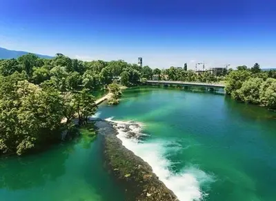 a river with green water and trees and a bridge at Apartman Zen in Bihać