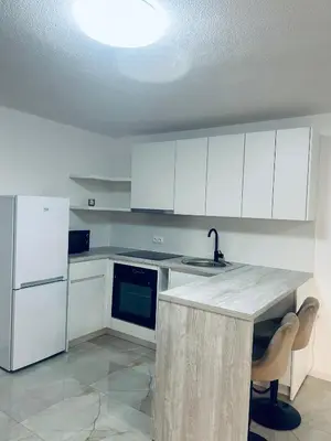 a kitchen with white cabinets and a sink and refrigerator at Apartman Zen in Bihać