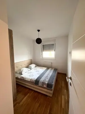a bedroom with a bed in a room with a window at stan na dan Tivana Doboj in Doboj