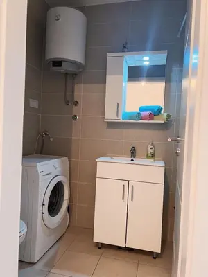 a bathroom with a washing machine and a sink at stan na dan Tivana Doboj in Doboj