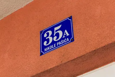 a blue sign on the side of a building at Apartman Rest 'n' Go in Doboj