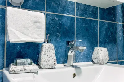 a bathroom with a sink with a faucet and towels at Apartman Rest 'n' Go in Doboj