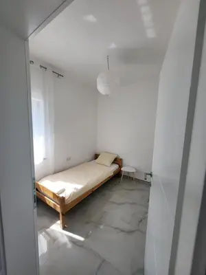 a small bedroom with a bed in a white room at Kuća za odmor PLAVA LAGUNA in Bihać