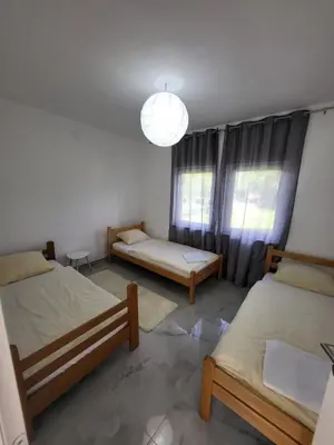 a room with two beds and a large window at Kuća za odmor PLAVA LAGUNA in Bihać