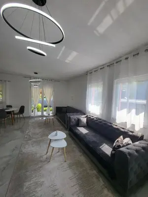 a living room with a black couch and a table at Kuća za odmor PLAVA LAGUNA in Bihać
