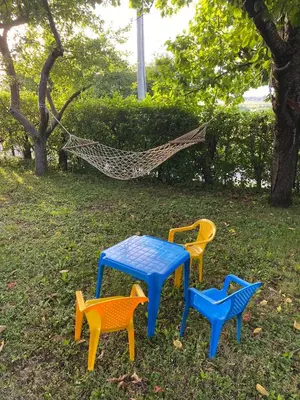 four colorful tables and a hammock in the grass at Vikendica Lucija in Livno
