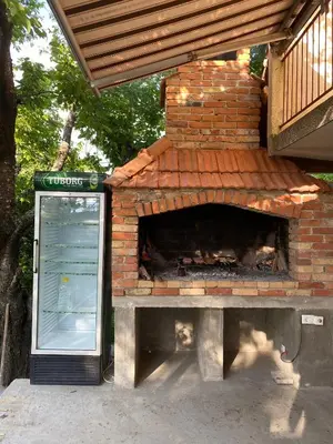 a brick pizza oven sitting next to a building at Vikendica Lucija in Livno