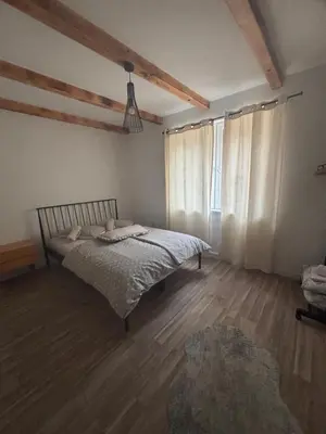 a bedroom with a bed in a room with wooden floors at Ranch Jajce in Jezero