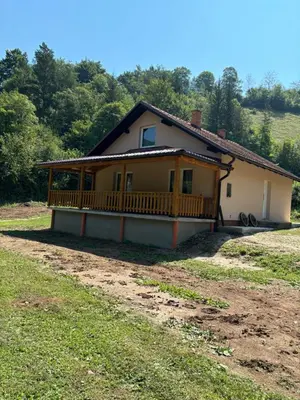 a house with a large porch on a field at Ranch Jajce in Jezero