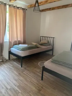 two beds in a room with wooden floors at Ranch Jajce in Jezero