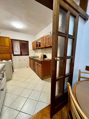a large kitchen with wooden cabinets and a table at Harmonija - Trn, Banjaluka in Laktaši