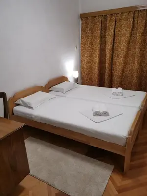 a bedroom with a bed with two slippers on it at Harmonija - Trn, Banjaluka in Laktaši