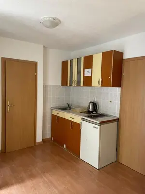 a kitchen with brown cabinets and a white appliance at Apartmani Centar Fojnica in Fojnica
