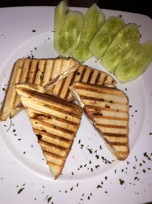 a white plate with waffles and pickles on it at Sobe Dado, Gostionica Kod Dade in Banja Luka