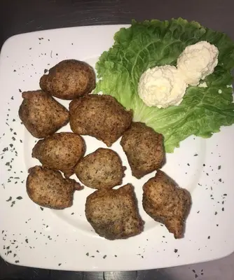 a plate of food with meatballs and lettuce and cauliflower at Sobe Dado, Gostionica Kod Dade in Banja Luka
