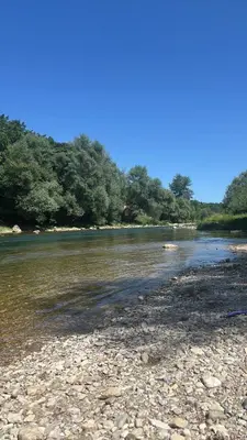 a river with rocks and trees in the background at Sobe Dado, Gostionica Kod Dade in Banja Luka