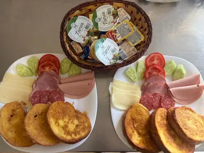 two plates with different types of cheese and a basket of food at Sobe Dado, Gostionica Kod Dade in Banja Luka