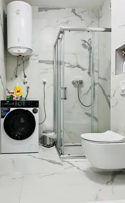 a bathroom with a shower and a washing machine at LookView apartment in Bihać