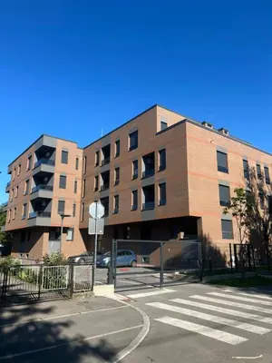 a largeartment building with a parking lot in front of it at Apartman City Centar Banjaluka in Banja Luka