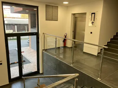 a staircase in a building with a glass railing at Apartman City Centar Banjaluka in Banja Luka