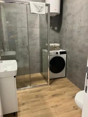 a bathroom with a shower with a microwave in it at Apartman City Centar Banjaluka in Banja Luka