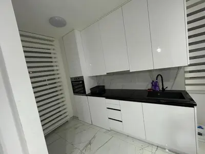a white kitchen with a sink and white cabinets at Apartman City Centar Banjaluka in Banja Luka