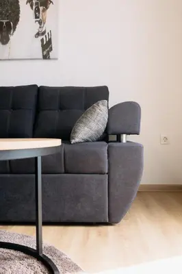 a black couch in a living room with a table at BDD House in Banja Luka