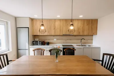 a kitchen with a wooden table with chairs at BDD House in Banja Luka