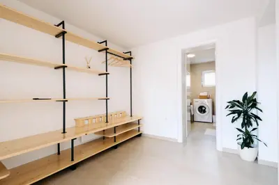 a room with wooden shelves and a white wall at BDD House in Banja Luka