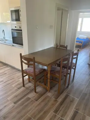 a dining room table with chairs and a kitchen at Vidovdanska house in Šipovo