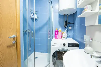 a bathroom with a washing machine and a shower at Šarmantan stan u centru grada in Banja Luka