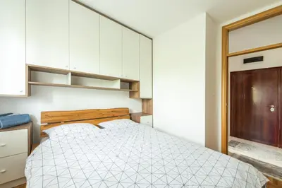 a bedroom with a bed and white cabinets at Šarmantan stan u centru grada in Banja Luka