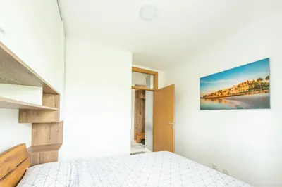a bedroom with a bed and a painting on the wall at Šarmantan stan u centru grada in Banja Luka