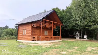a log cabin in a field with a yard at Brvnara Gold Hill in Prijedor
