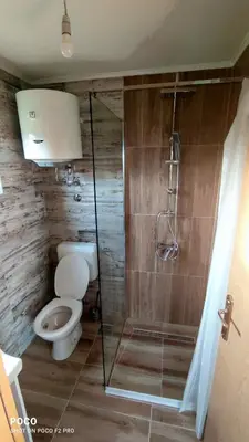 a bathroom with a toilet and a glass shower at Brvnara Gold Hill in Prijedor
