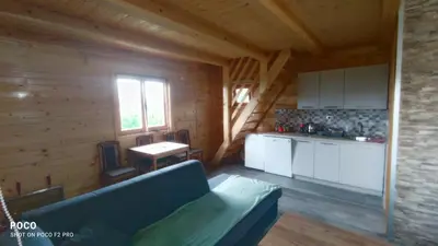 a living room with a blue couch in a log cabin at Brvnara Gold Hill in Prijedor